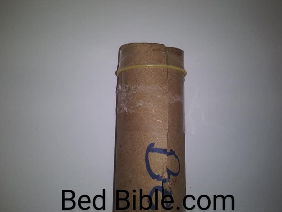 How to make an ice dildo in 6 easy steps. Photo of the top of the cardboard tube with the condom inside and the end folded over the top of the tube.