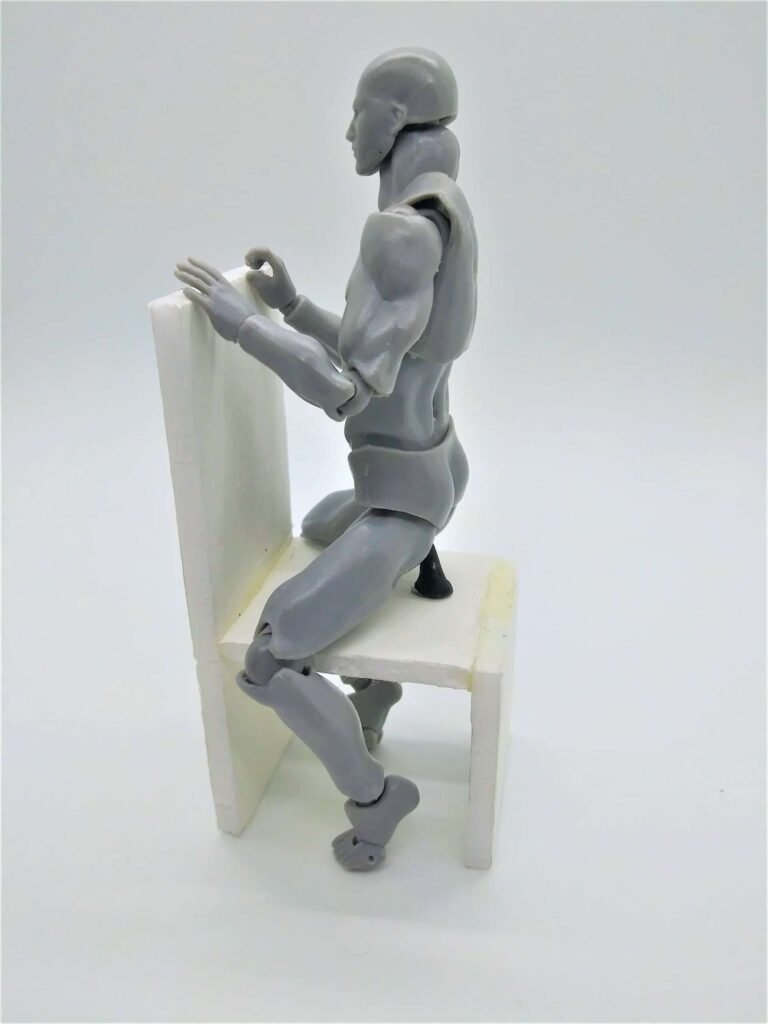 Positions for using a dildo for men: photo of a male figure straddling a chair backward and using a suction cup dildo.