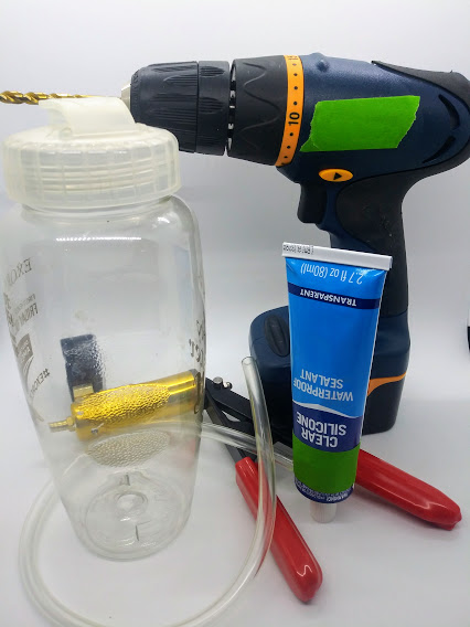 DIY penis pump; photo showing a water bottle, drill, silicone sealant, plastic tubing and a automitive hand pump.