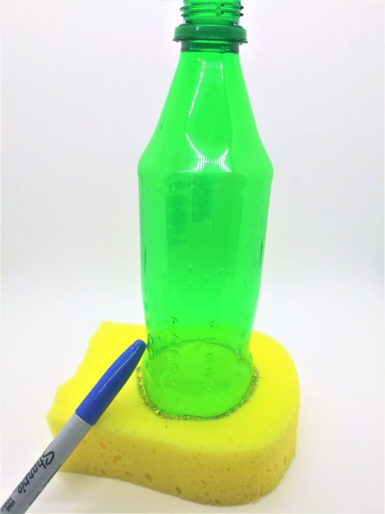 Homemade penis pump directions; photo of step 5 and the bottom of the soda bottle on top of a sponge and being traced around with a marker.