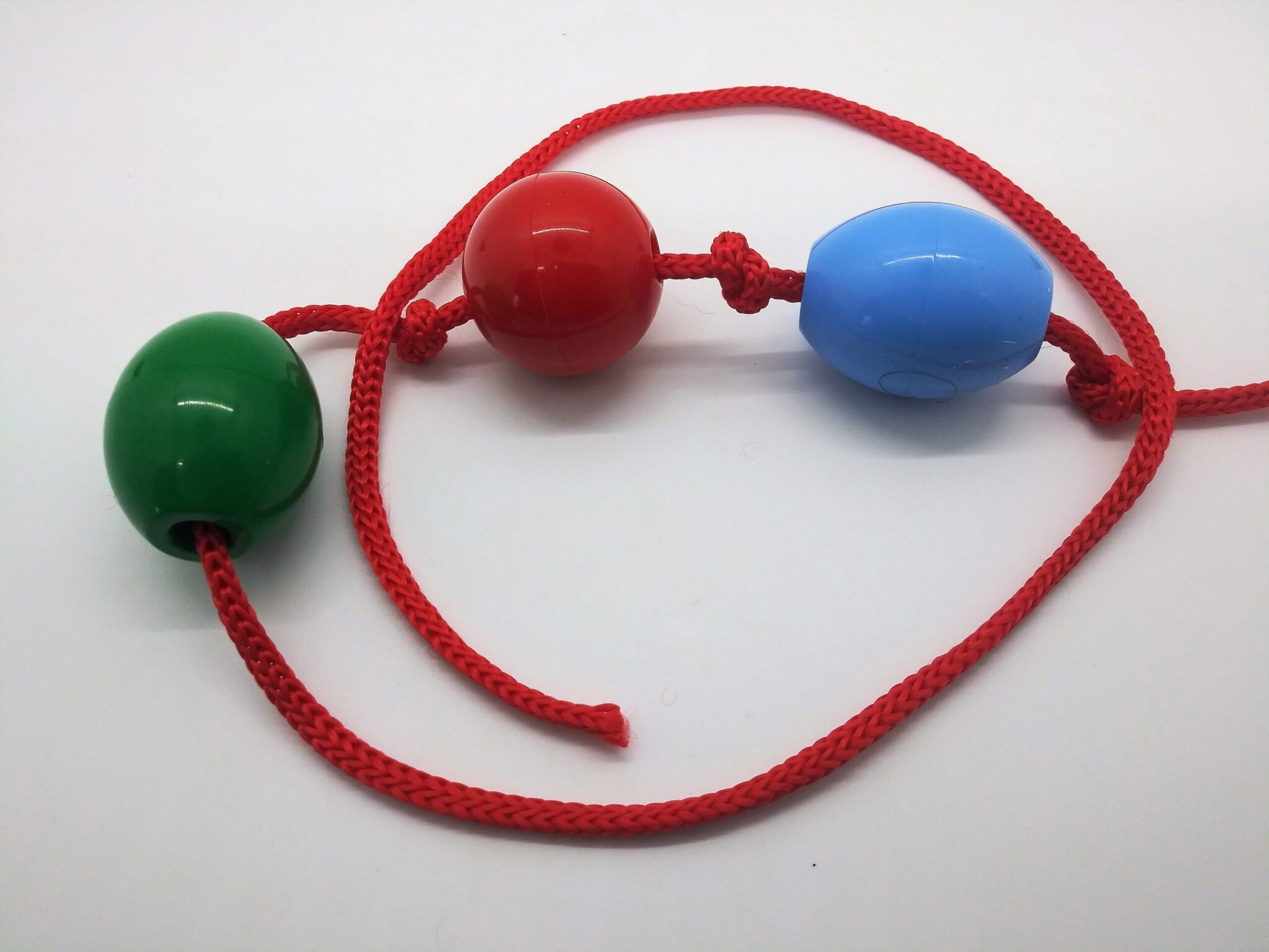 DIY anal beads. photo of 5 plastic beads strung on red nylon rope with knots tied in between each bead.