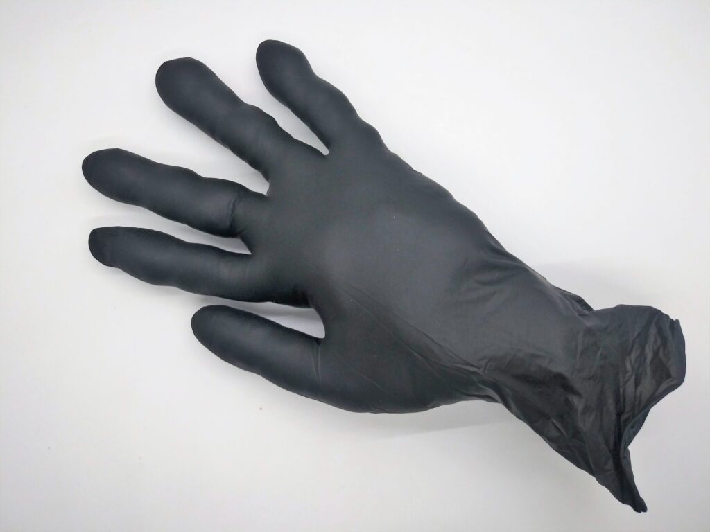 Homemade anal sex toys from gloves. Photo of a black medical glove stuffed with cotton balls.