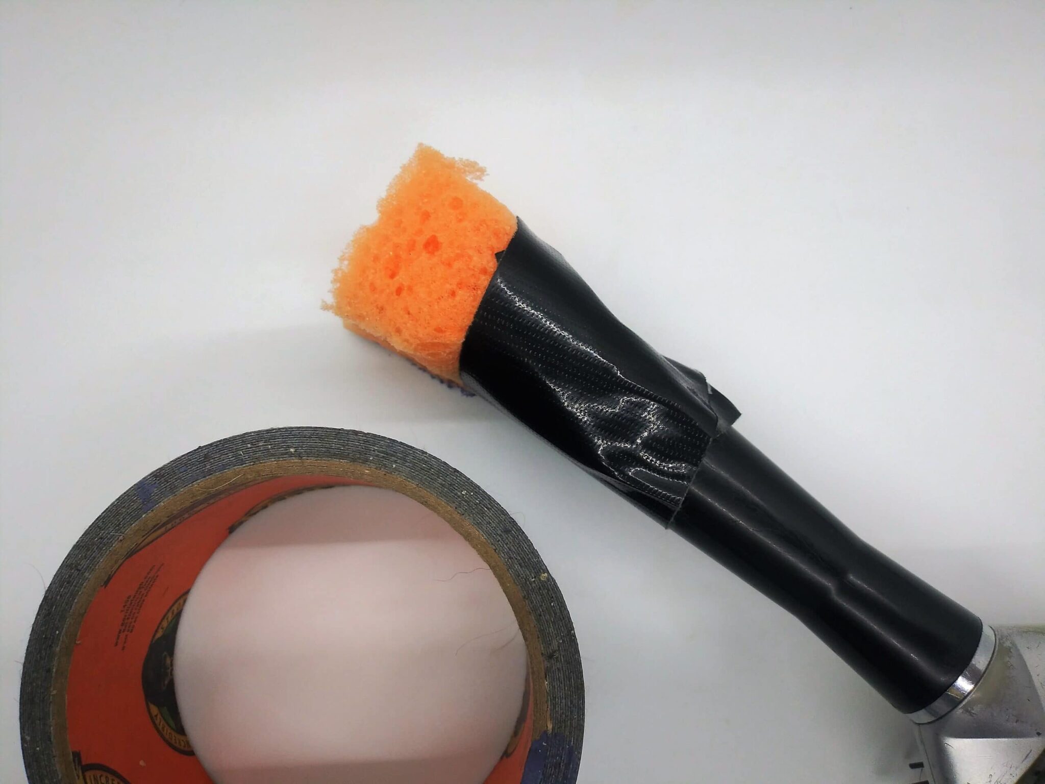 DIY anal sex toy made from a hairbrush, photo of a piece of sponge taped to the end of the brush handle.