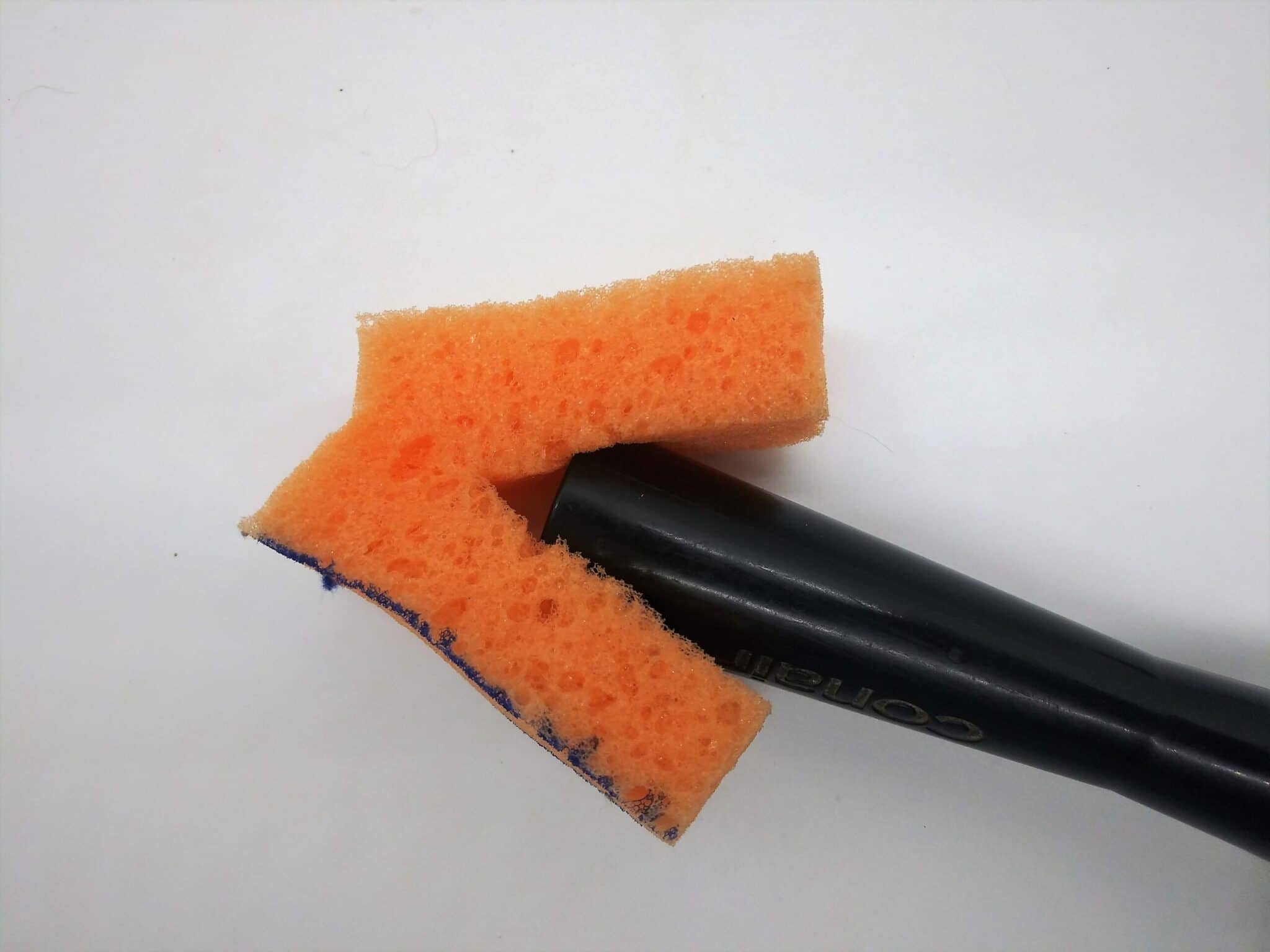 DIY anal sex toy made from a hairbrush ,photo of a small sponge piece being added to the end of the hairbrush handle.