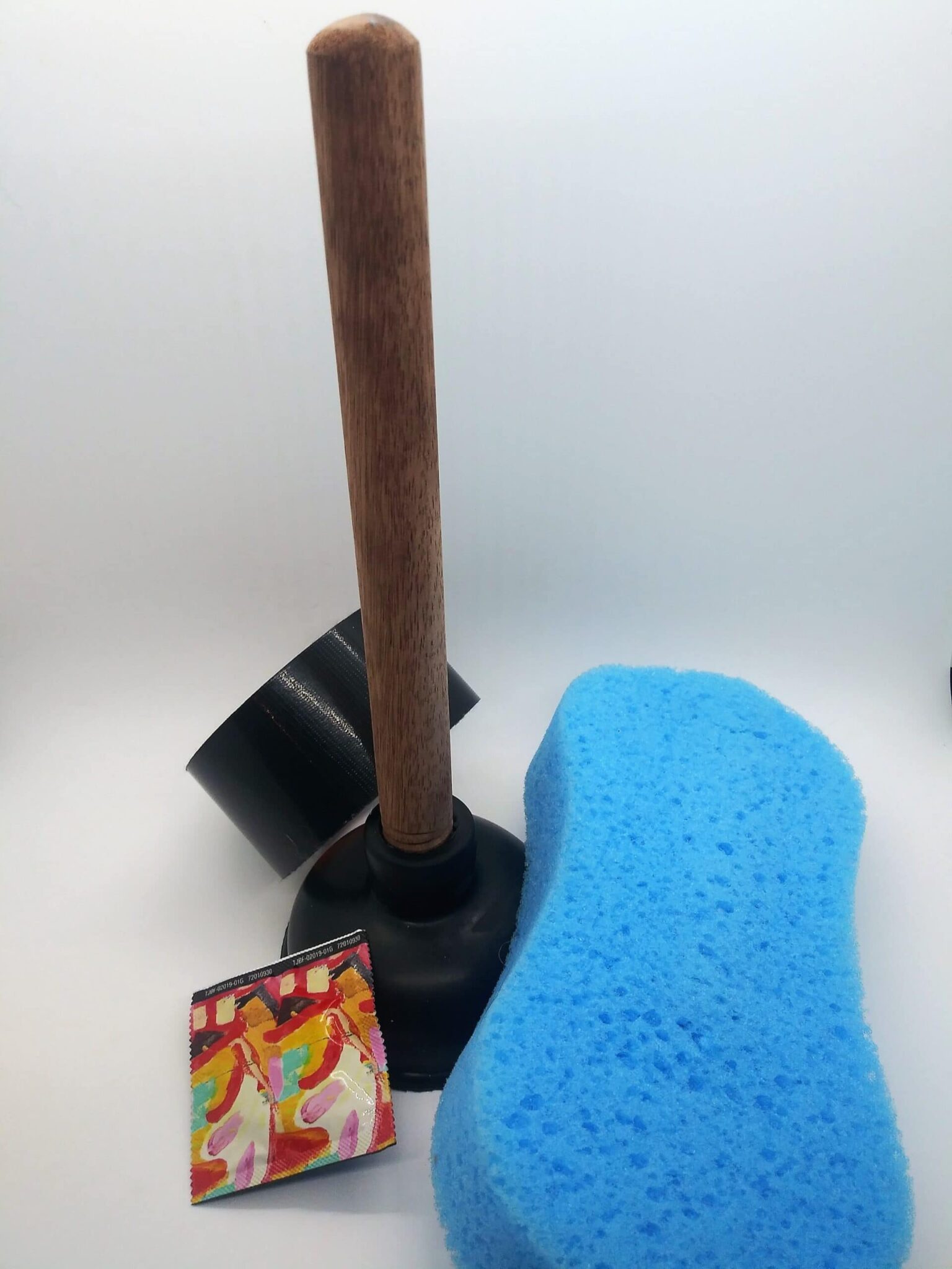 DIY anal toys, making a toy from a sink plunger. Photo of a sink plunger, large sponge, duct tape and a condom.