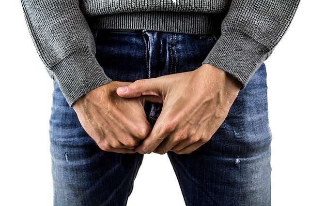 Homemade penis pump; panis injury, photo of man holding his crotch.