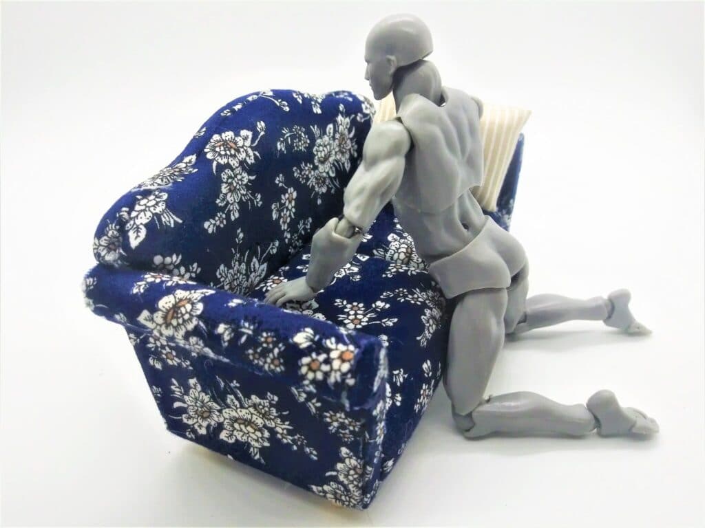 A figurine demonstrating how to tuck your masturbator under the couch cushions during use.