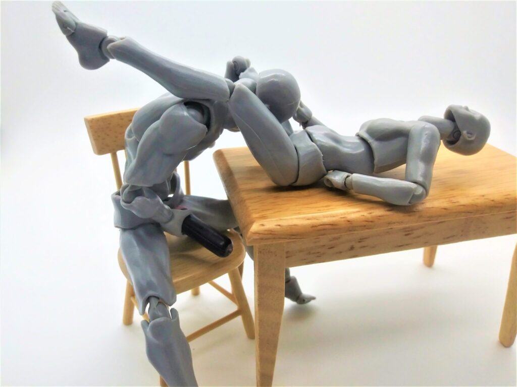 Figures demonstrating a position for performig oral sex while using a masturbator.
