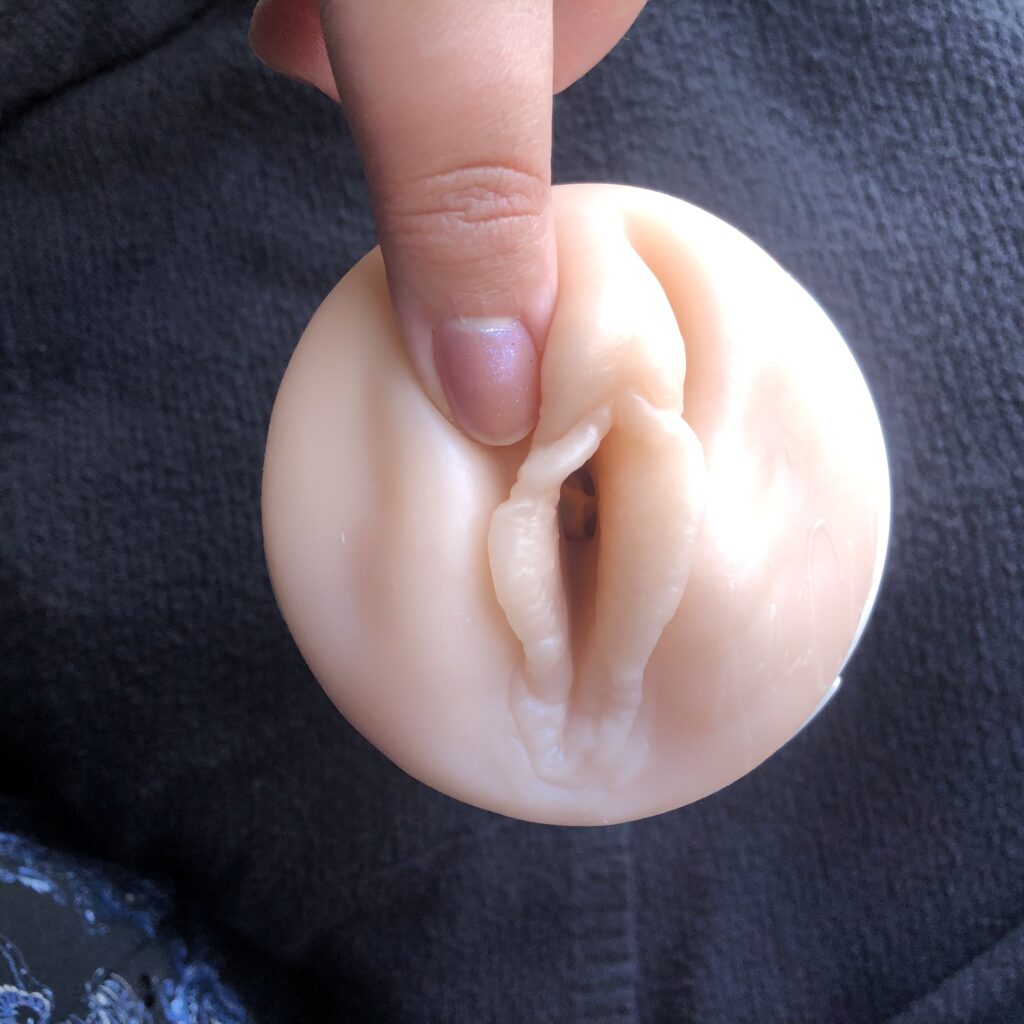 Thumb rolling the clitoris on a fleshlight