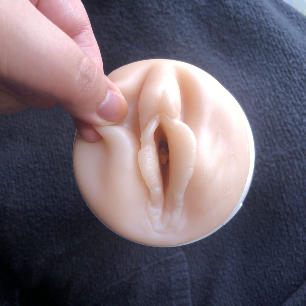 Fingers tugging the labia of a fleshlight